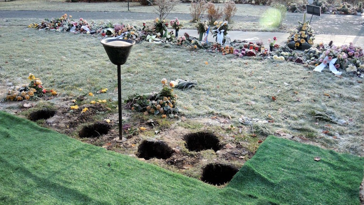Offene Urnengräber mit Blumenschmuck